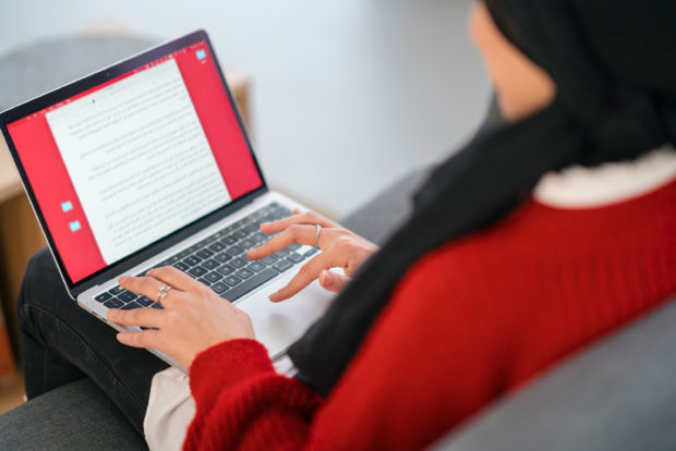 Person typing on laptop keyboard